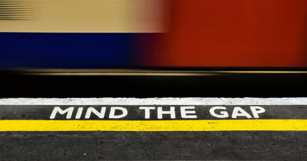 Mind the gap message at train station cues people to remember the security gap.