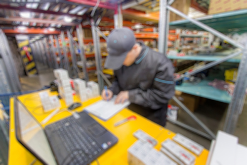 A man working in a auto-parts warehouse to show how cross platform database monitoring works for regional suppliers.